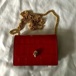 Brand new Alexander McQueen red skull card holder with chain.